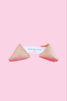 two triangular shaped objects on a pink background