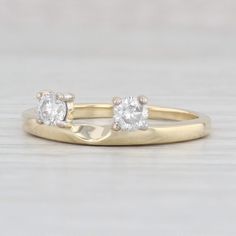 two diamond engagement rings sitting on top of each other