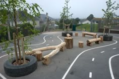 an empty playground with trees and tires