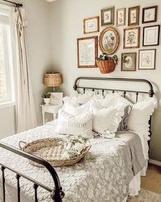 a bedroom with white bedding and pictures on the wall