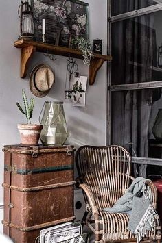 an old suitcase is sitting in front of a shelf with plants and other things on it