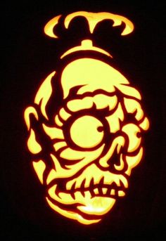 a carved pumpkin with an image of a demon on it's face in the dark