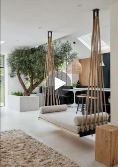 a living room filled with lots of furniture and hanging plants on the wall next to it