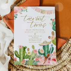 the wedding card is sitting on top of a basket with flowers and cacti