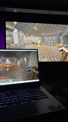 two laptops sitting next to each other in front of a computer screen with minecraft on it