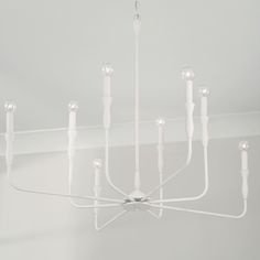 a white chandelier with eight lights hanging from it's sides and four arms