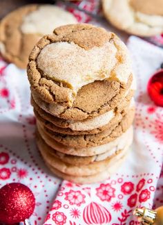 a stack of cookies sitting on top of a red and white cloth next to christmas ornaments