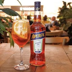 a bottle of aperol next to a glass filled with liquid