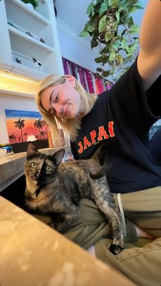 a woman sitting on the floor with her cat