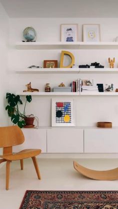 a living room filled with furniture and lots of shelves above the couches on top of them