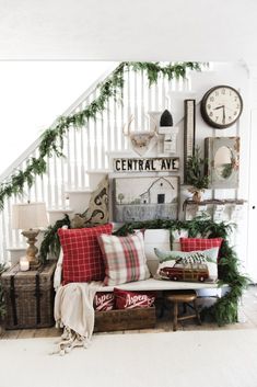 a living room filled with lots of furniture and christmas decorations on top of the stairs