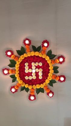 a decorated wall with candles and flowers in the shape of a letter b on it