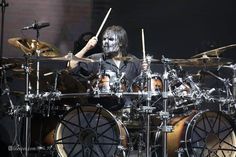 a man with makeup painted on his face playing drums