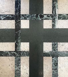 a black and white checkered floor with a cross in the middle on it's side