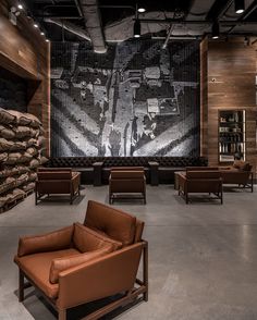 an empty room with leather chairs and a large painting on the wall