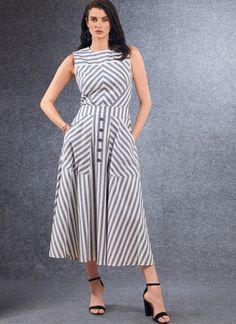 a woman in a striped dress standing with her hands on her hips