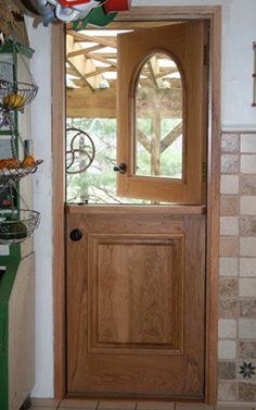 a wooden door in a bathroom next to a tiled wall