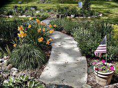 a garden with flowers and flags in the background