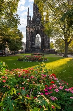 an old building surrounded by flowers and trees