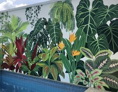 a mural on the side of a building near a swimming pool