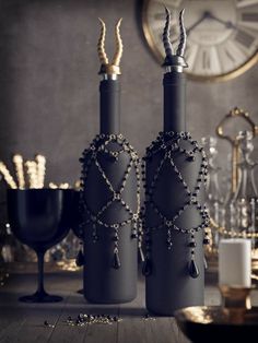 two black vases sitting on top of a wooden table