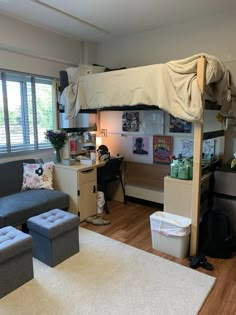 a loft bed sitting in the middle of a living room next to a desk and chair