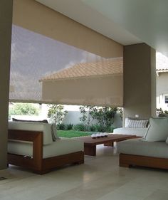 a living room with couches and tables in front of a large open patio area