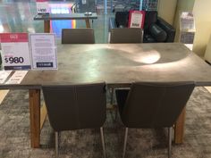 a table with four chairs in front of it and a price sign on the table