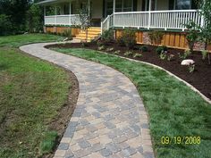 a brick walkway in front of a house