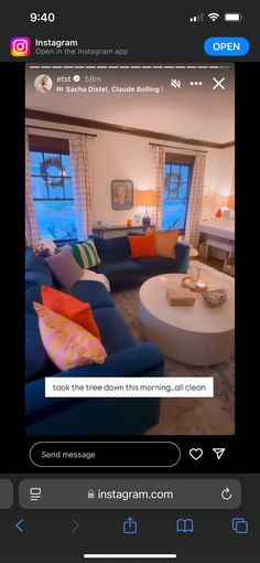 an image of a living room with blue couches and orange pillows on the coffee table