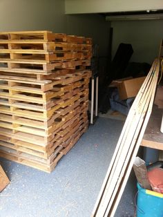 several stacks of wooden pallets stacked on top of each other in a garage area