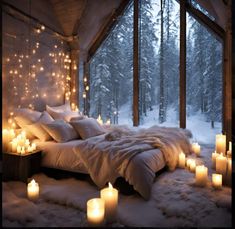 a bed covered in lots of candles next to a window with snow on the ground