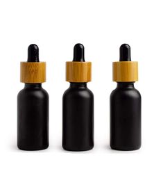 three black glass bottles with bamboo caps