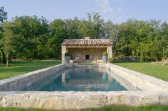 an outdoor pool surrounded by grass and trees