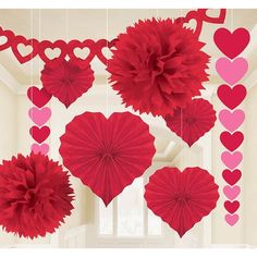 valentine's day decorations hanging from the ceiling with paper hearts and pom poms