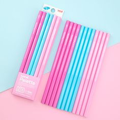 four blue and pink pencils sitting next to each other on top of a pink surface