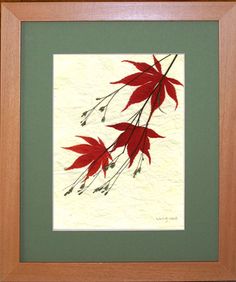 a painting with red leaves in a wooden frame