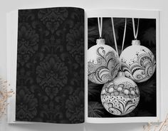 an open photo book with ornaments hanging from it's sides and the pages opened