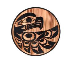 a carved wooden plate with an eagle on it's face in black and orange