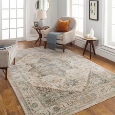 a living room with white walls and wooden floors, an area rug that has been placed on the floor