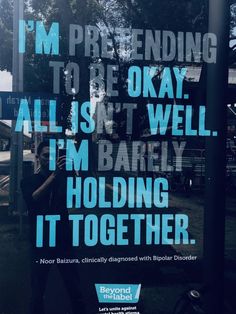 a man standing in front of a sign that says i'm pretending to be okay all isn't well im barely holding it together