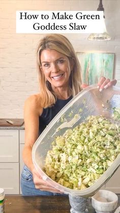 a woman is holding up a large bowl full of chopped vegetables and the words how to make green goddess slaw