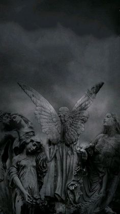 an angel statue surrounded by other statues on a dark background with the sky in the background