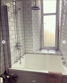 a bath tub sitting next to a window in a bathroom