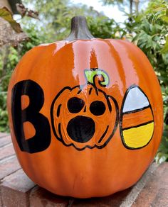 a pumpkin with the word boo painted on it's side and a dog paw