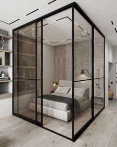 a bedroom with glass walls and a bed in the middle, surrounded by shelves filled with books