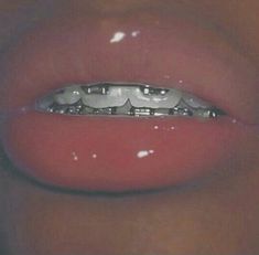 a close up view of a person's mouth with an open mouth and metal ring on the lip