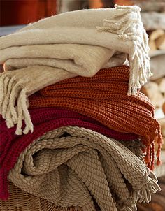 several blankets stacked on top of each other in a basket