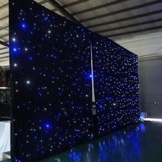 a large screen with blue lights on it in a warehouse or office building that is lit up at night