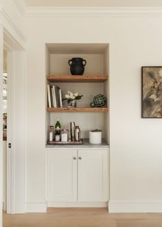 the shelves in this room are filled with bottles and other items, including vases